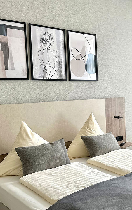 City Hotel Hameln Ein großes Bett mit drei Bildern an der Wand