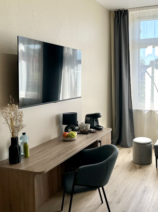 Unterkunft in Hameln Ein stuhl, ein Tisch und ein Fernseher an der Wand